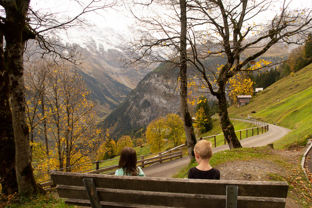 Kids on bench looking out over Swiss Alps